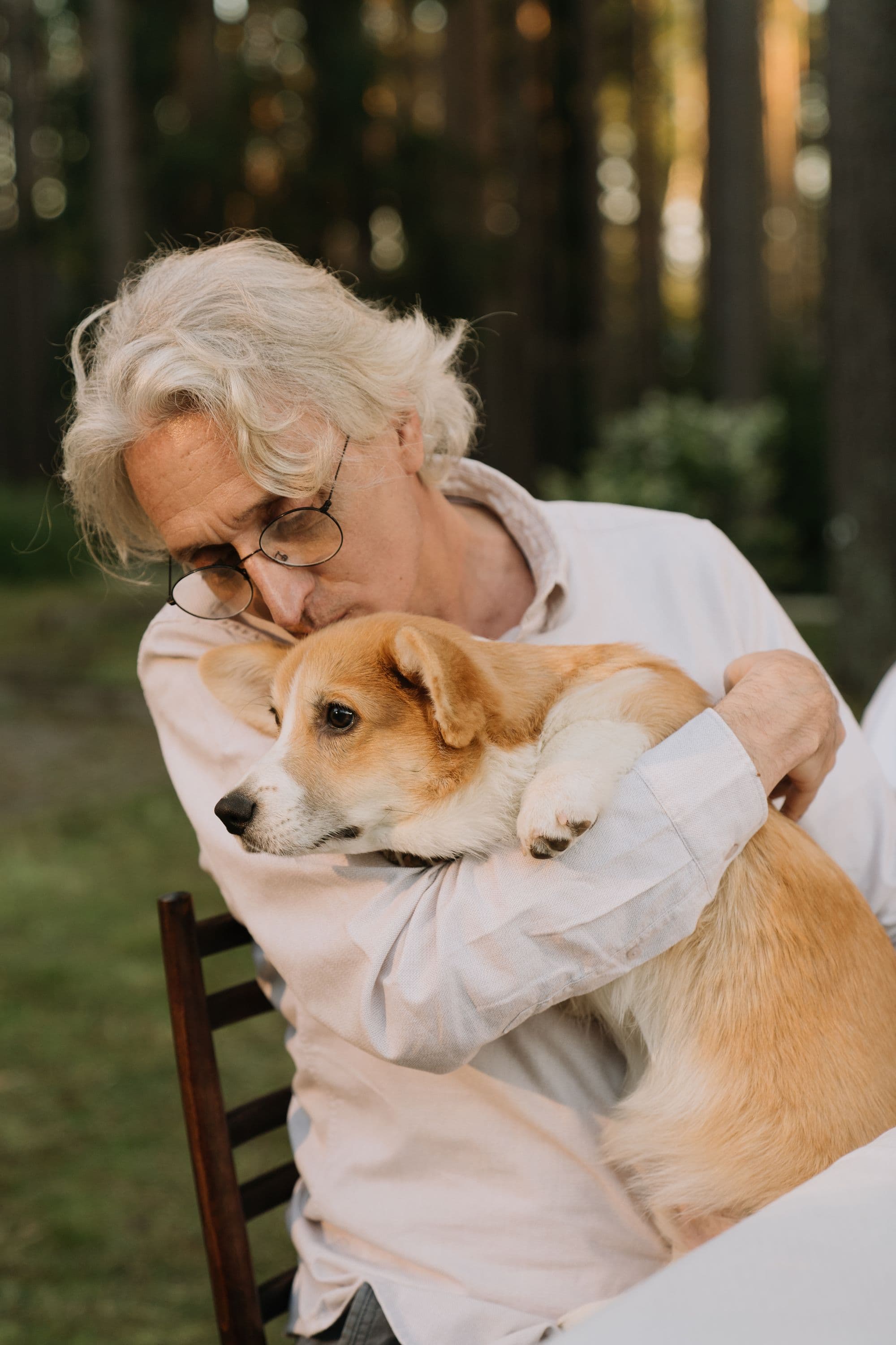 A grandmother hugging her corgi