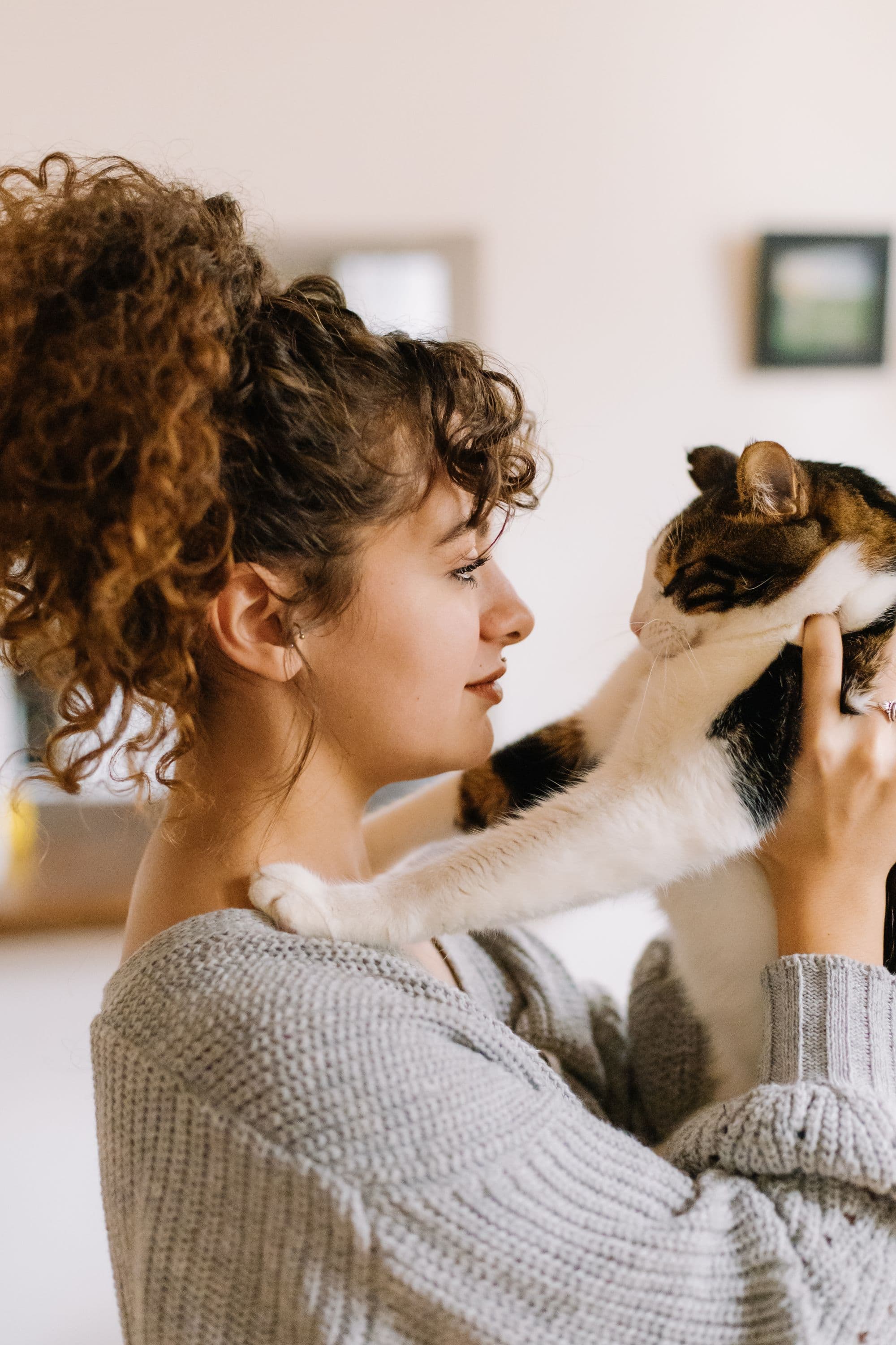 A woman holding her cat at home